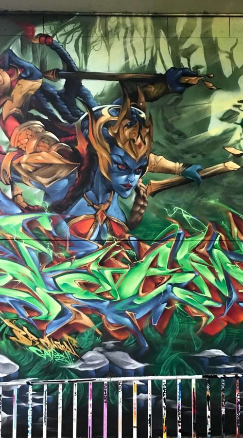 Graffiti de guerrera azul en un bosque con letras wildstyle. Festival Meeting Of Styles en Wiesbaden, Alemania