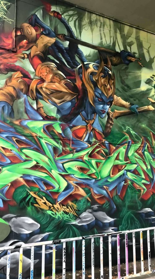 Graffiti de guerrera azul en un bosque con letras wildstyle. Festival Meeting Of Styles en Wiesbaden, Alemania