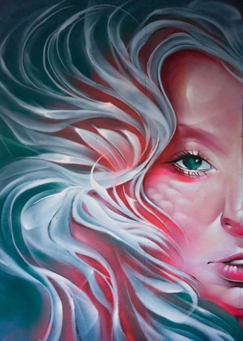 Mural retrato femenino hiperrealista en tonos rosados y blancos