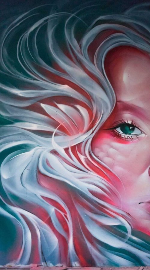 Mural retrato femenino hiperrealista en tonos rosados y blancos