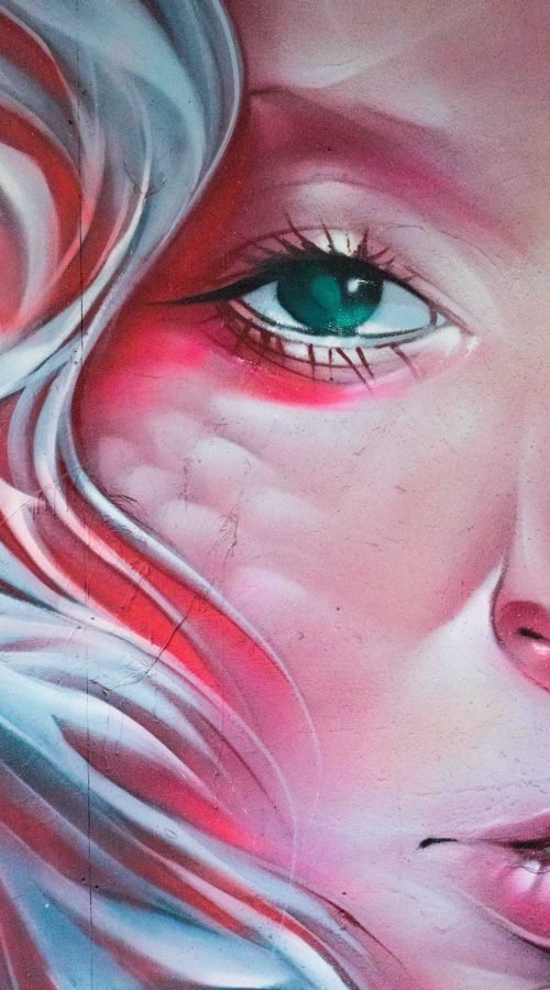 Mural retrato femenino hiperrealista en tonos rosados y blancos