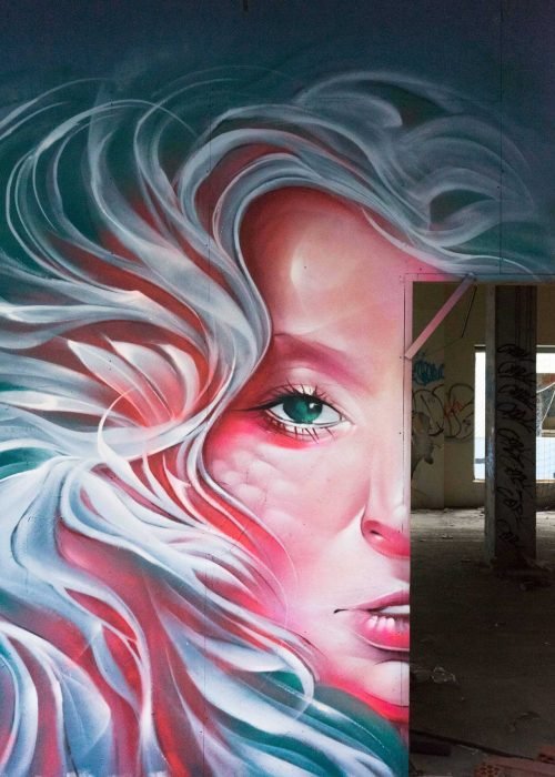 Mural retrato femenino hiperrealista en tonos rosados y blancos