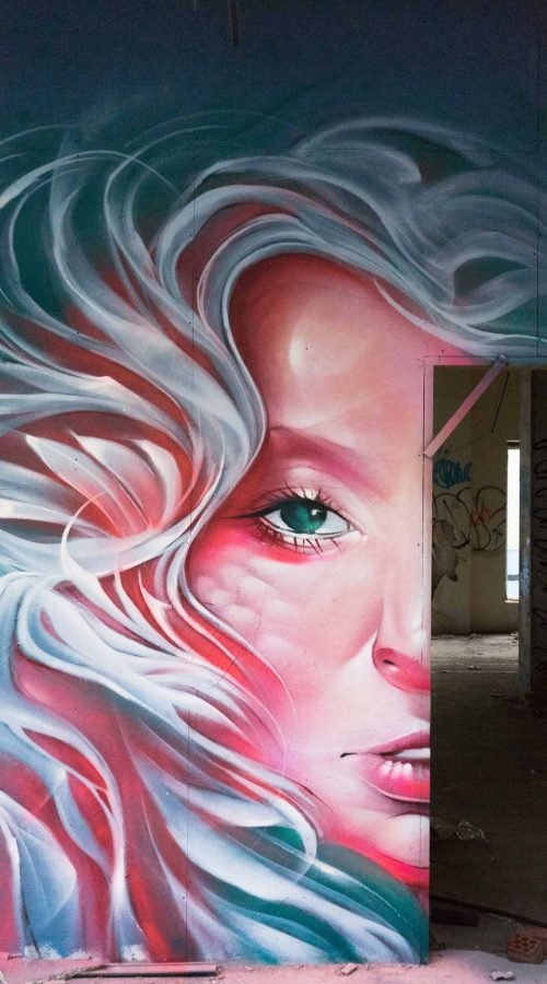 Mural retrato femenino hiperrealista en tonos rosados y blancos
