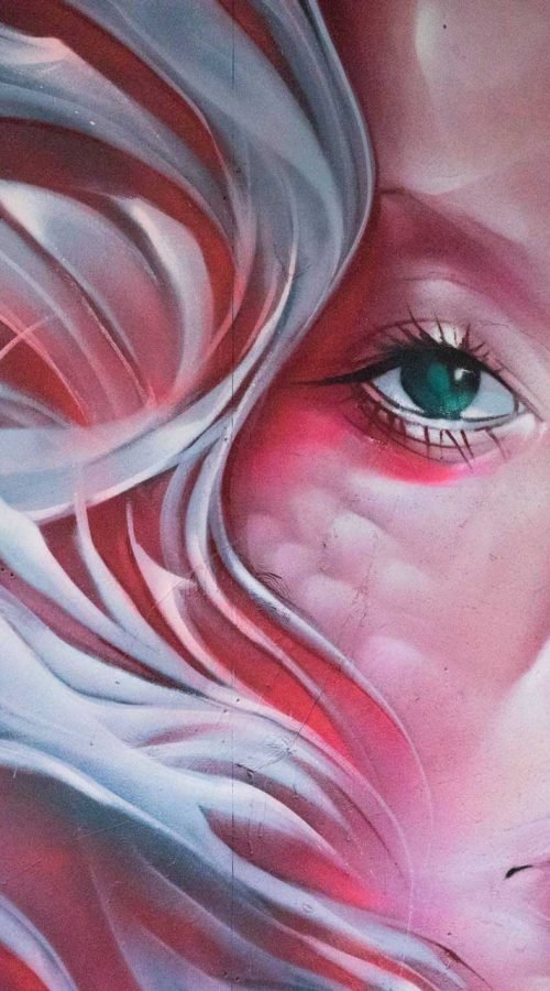 Mural retrato femenino hiperrealista en tonos rosados y blancos