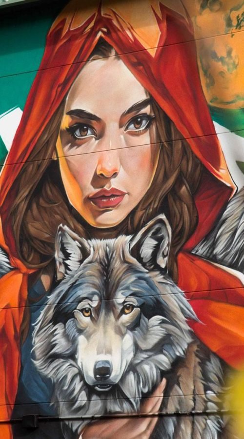 Primer plano del mural de Caperucita Roja con tres lobos en colegio de Madrid