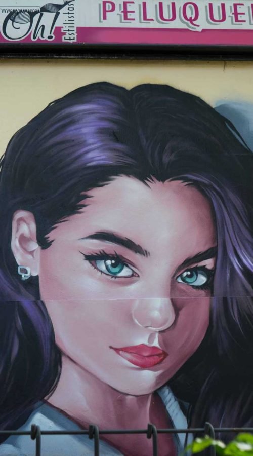 Graffiti de mujer en fachada de Oh Peluqueros en el Barrio del Pilar, Madrid