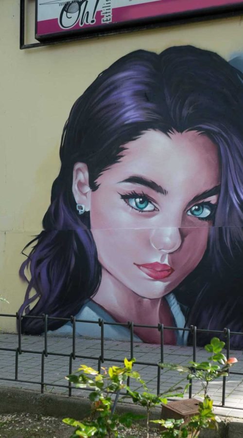 Graffiti de mujer en fachada de Oh Peluqueros en el Barrio del Pilar, Madrid