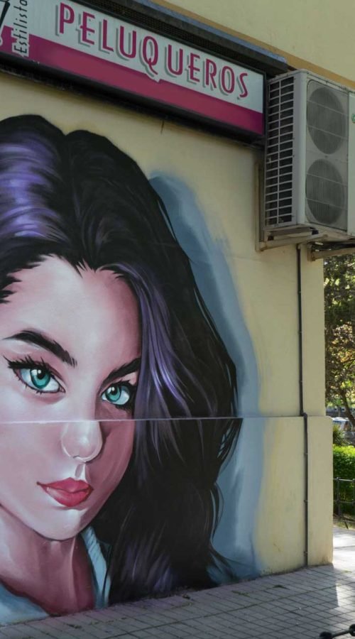 Graffiti de mujer en fachada de Oh Peluqueros en el Barrio del Pilar, Madrid