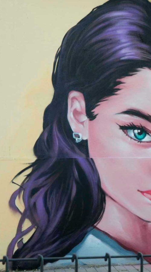 Graffiti de mujer en fachada de Oh Peluqueros en el Barrio del Pilar, Madrid