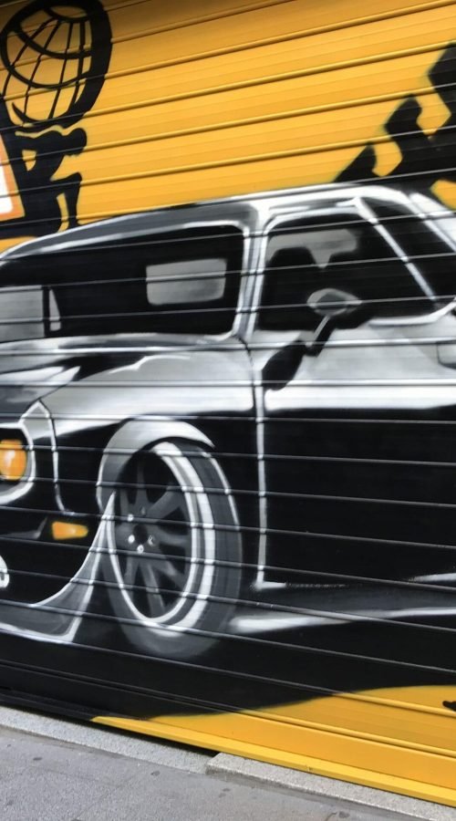 Graffiti de coche deportivo en sede de Autoescuelas Gala en Gran Vía