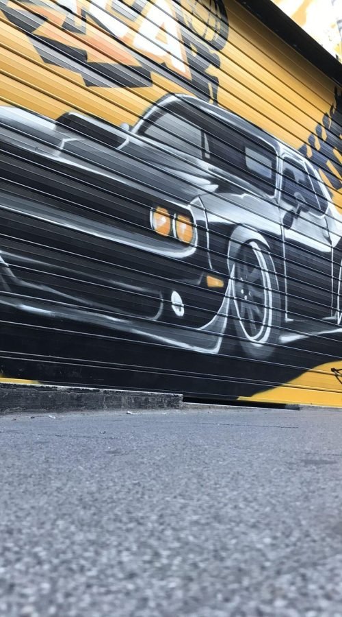 Graffiti de coche deportivo en sede de Autoescuelas Gala en Gran Vía