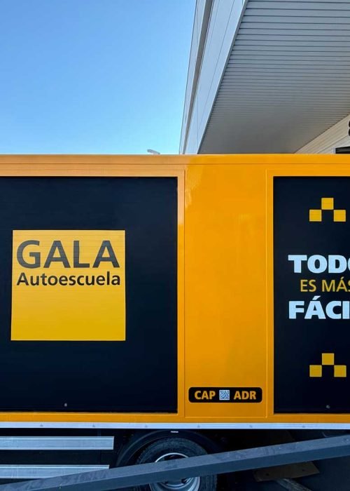 Camión amarillo y negro con rotulación de Autoescuela Gala y lema "Todo es más fácil"