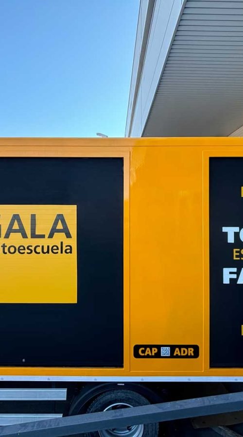 Camión amarillo y negro con rotulación de Autoescuela Gala y lema "Todo es más fácil"