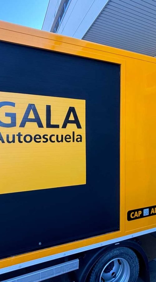 Camión amarillo y negro con rotulación de Autoescuela Gala y lema "Todo es más fácil"