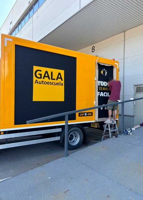 Camión amarillo y negro con rotulación de Autoescuela Gala y lema "Todo es más fácil"