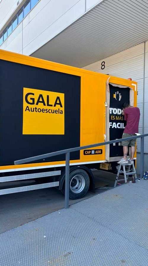 Camión amarillo y negro con rotulación de Autoescuela Gala y lema "Todo es más fácil"