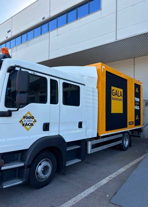 Camión amarillo y negro con rotulación de Autoescuela Gala y lema "Todo es más fácil"