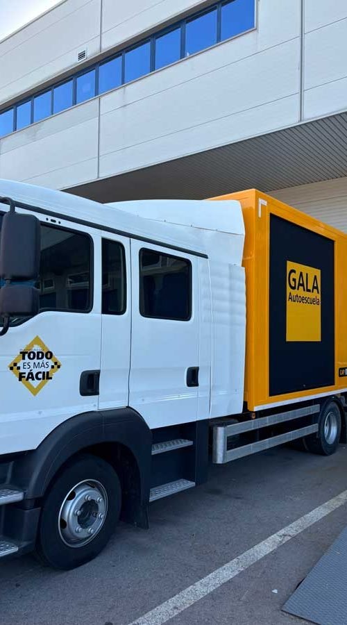 Camión amarillo y negro con rotulación de Autoescuela Gala y lema "Todo es más fácil"