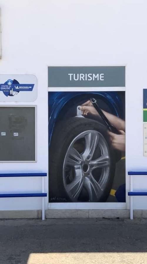 Graffiti profesional con imágenes de coches en taller Euromaster Tortosa