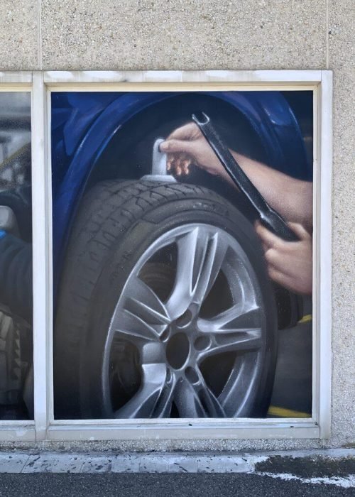 Graffiti profesional con imágenes de coches en taller Euromaster Tortosa