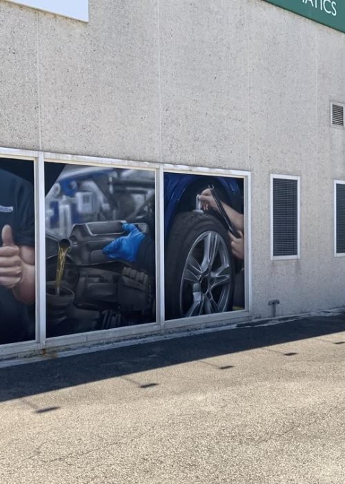 Graffiti profesional con imágenes de coches en taller Euromaster Tortosa