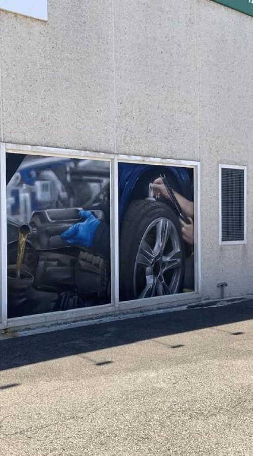 Graffiti profesional con imágenes de coches en taller Euromaster Tortosa