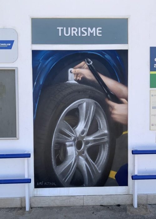 Graffiti profesional con imágenes de coches en taller Euromaster Tortosa