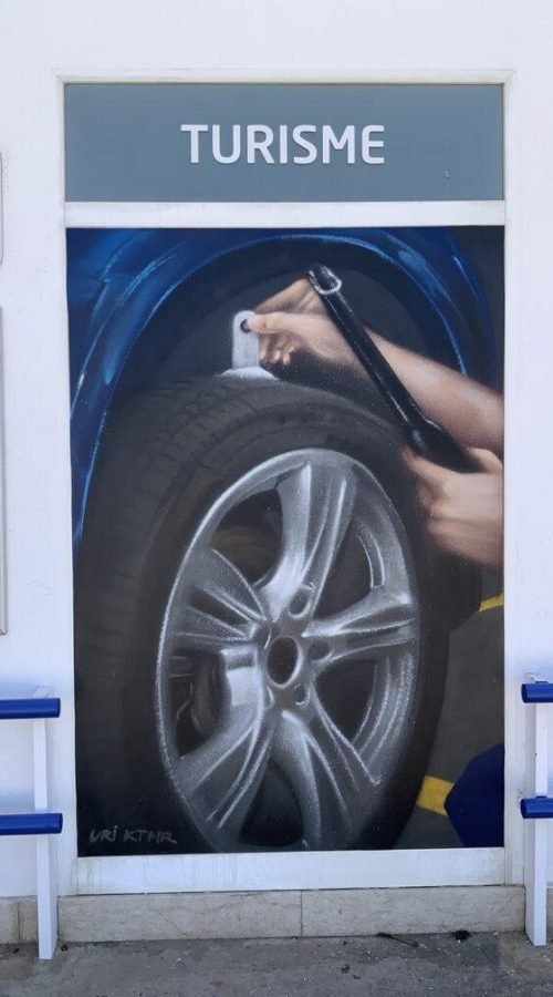 Graffiti profesional con imágenes de coches en taller Euromaster Tortosa