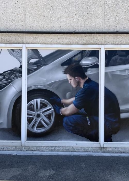 Graffiti profesional con imágenes de coches en taller Euromaster Tortosa