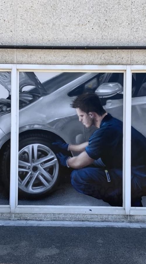 Graffiti profesional con imágenes de coches en taller Euromaster Tortosa