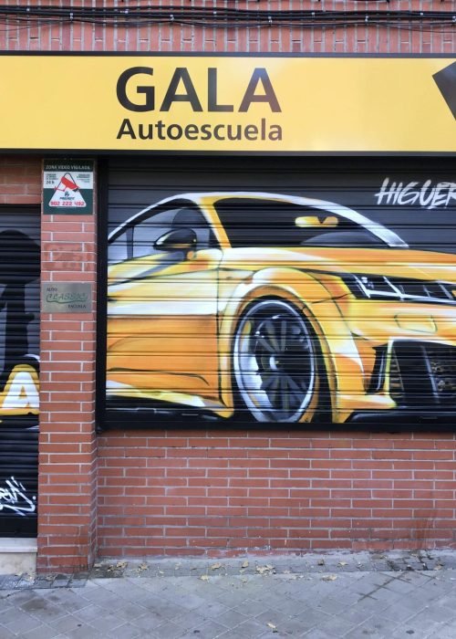 Graffiti de coche deportivo y Oso y Madroño en fachada de Autoescuela Gala