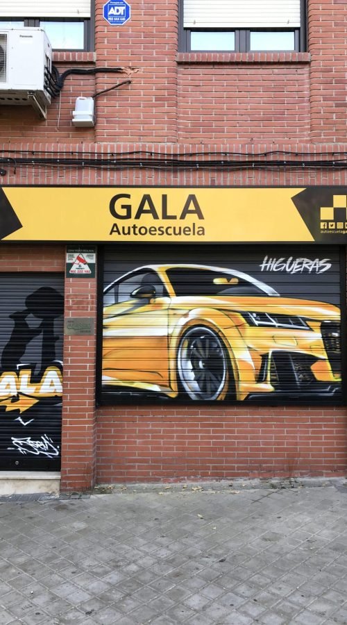 Graffiti de coche deportivo y Oso y Madroño en fachada de Autoescuela Gala