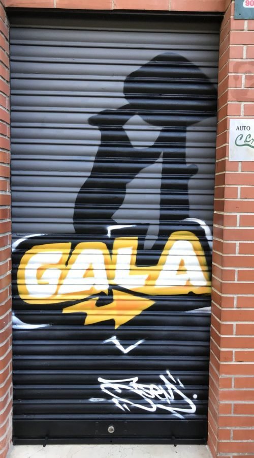 Graffiti de coche deportivo y Oso y Madroño en fachada de Autoescuela Gala