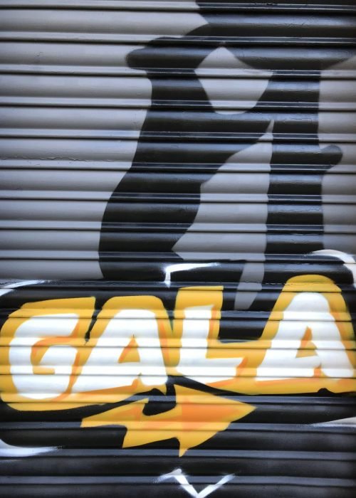 Graffiti de coche deportivo y Oso y Madroño en fachada de Autoescuela Gala