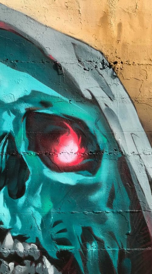 Graffiti de calavera azul con capucha y ojos rojos brillantes