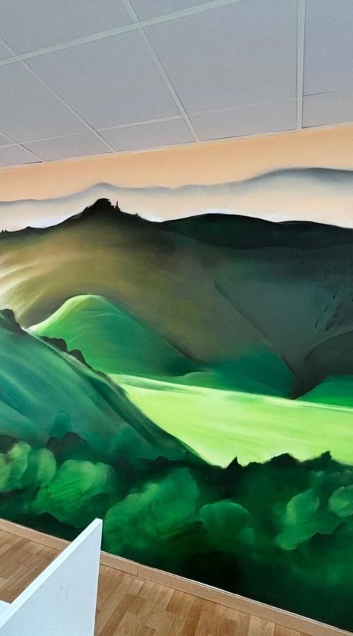 Paisaje mural en call center de Euromaster con montañas verdes