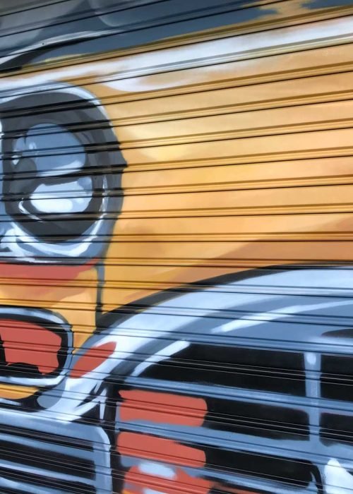 Coche clásico pintado en cierre de Autoescuela Gala Arturo Soria, graffiti realista