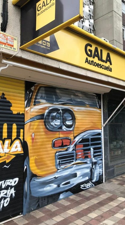 Coche clásico pintado en cierre de Autoescuela Gala Arturo Soria, graffiti realista