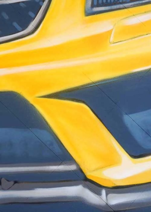 Mural con coche BMW amarillo en fachada de Autoescuela Gala Metropolitano