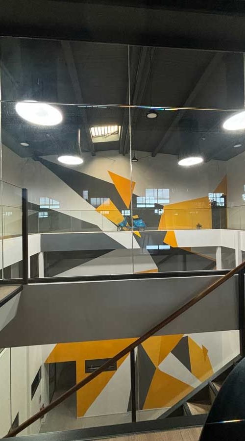 Mural geométrico en sede Gala FP, arte decorativo en interior a tres niveles
