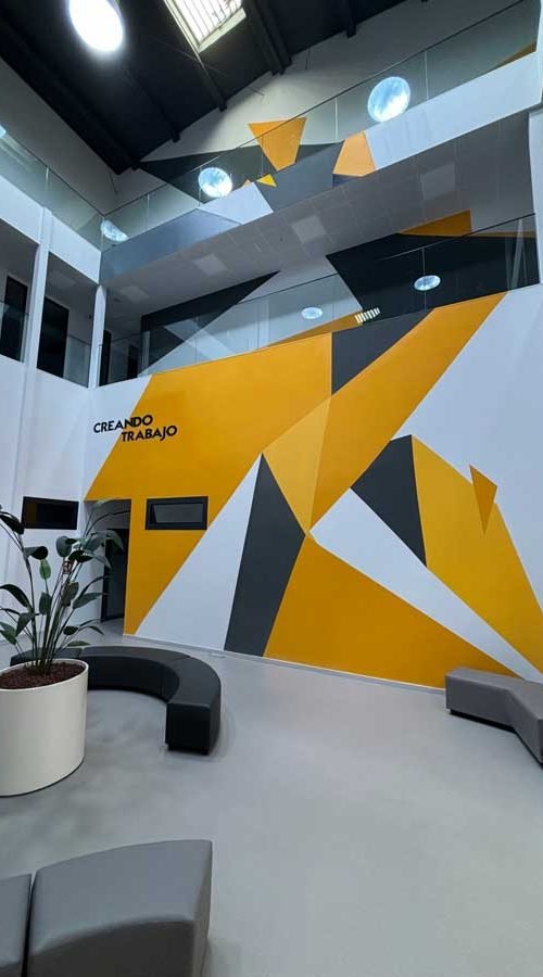 Mural geométrico en sede Gala FP, arte decorativo en interior a tres niveles