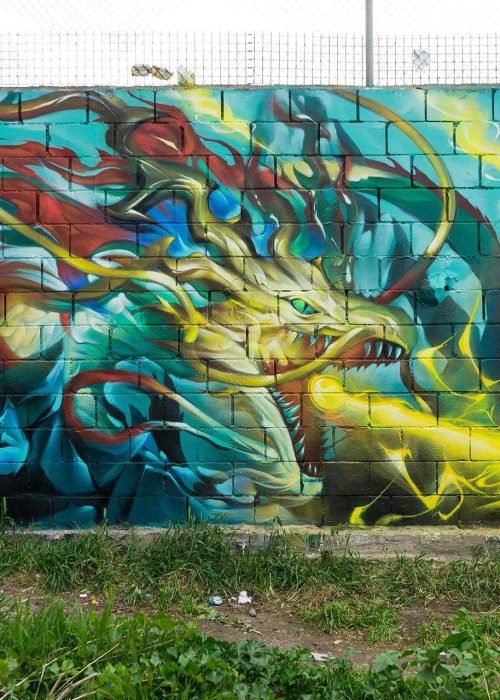 Graffiti de dragón lanzando fuego sobre fondo azul