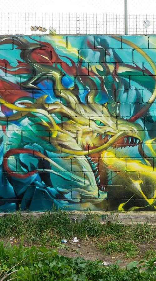 Graffiti de dragón lanzando fuego sobre fondo azul