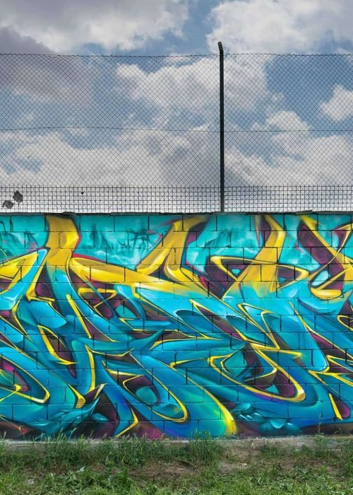 Graffiti de dragón lanzando fuego sobre fondo azul