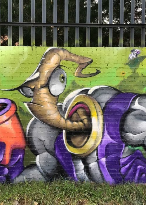 Mural graffiti de Earthworm Jim con raygun sobre fondo verde neón