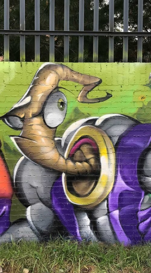 Mural graffiti de Earthworm Jim con raygun sobre fondo verde neón