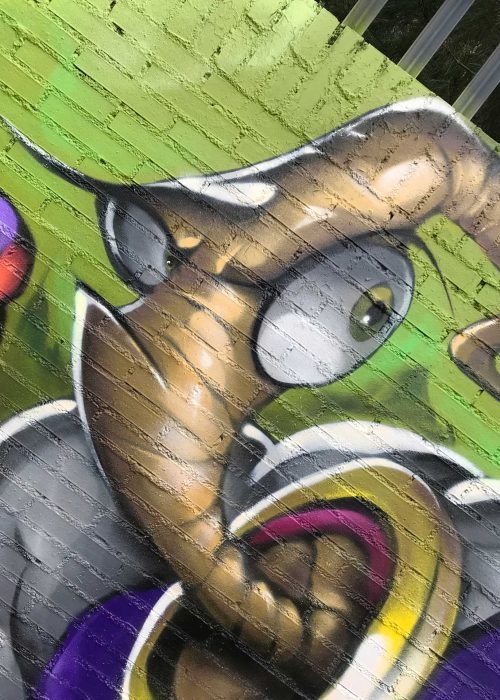 Mural graffiti de Earthworm Jim con raygun sobre fondo verde neón