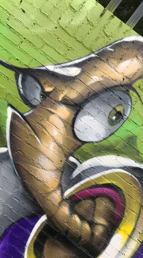 Mural graffiti de Earthworm Jim con raygun sobre fondo verde neón