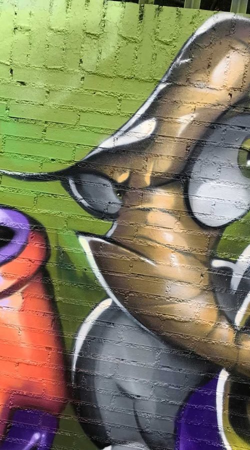 Mural graffiti de Earthworm Jim con raygun sobre fondo verde neón