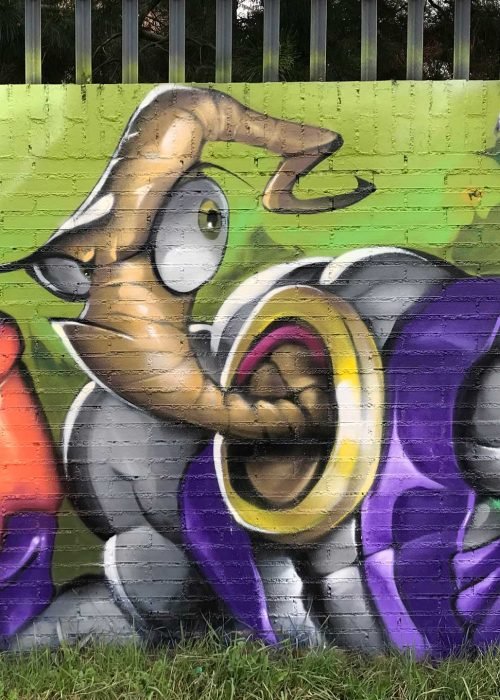 Mural graffiti de Earthworm Jim con raygun sobre fondo verde neón